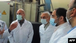 FILE - A picture provided by Iran's Atomic Energy Organization shows Iranian Parliament speaker Mohammad Bagher Ghalibaf, left, and head of the Iranian Atomic Organization Ali Akbar Salehi, right, at the Fordo Uranium Conversion Facility, Jan. 28, 2021.