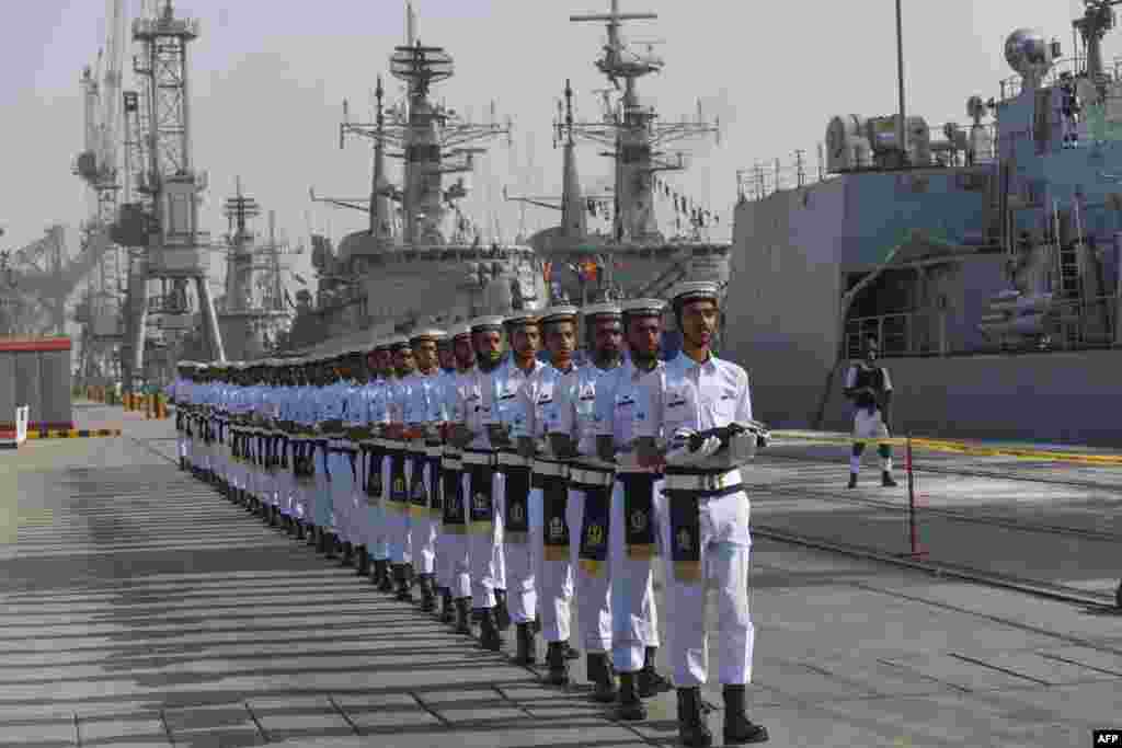 Pakistani Naval personnel march as they carry the flags of the countries participating in the navy&#39;s Multinational Exercise &#39;AMAN-19&#39; in Karachi.