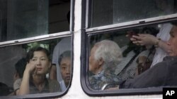 북한 평양 시내를 운행하는 전차에 탄 시민들.