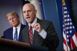 FILE - FDA Commissioner Dr. Stephen Hahn speaks as U.S. President Donald Trump listens during the daily briefing on the novel coronavirus in the Brady Briefing Room of the White House, April 21, 2020.