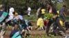 First lady Michelle Obama carries mustard plants for planting as she is joined by school children from across the country for the fourth annual White House Kitchen Garden spring planting, Monday, March 26,2012, at the White House.