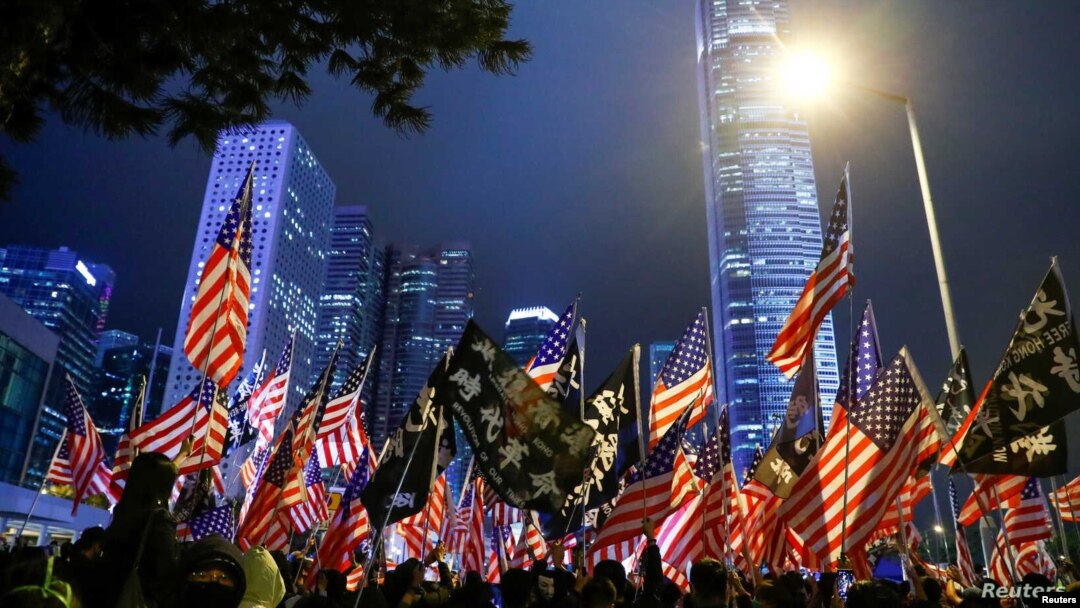 ARCHIVO - Manifestantes sostienen banderas de EE.UU. durante una reunión en el palacio Edinburgh en Hong Kong, el 28 de noviembre de 2019.