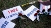 FILE - Roses and slogans reading ''Free Lee Ming-che'' are placed on the lawn during a media event to support Taiwanese activist Lee Ming-che detained in China, in Taipei, Taiwan, Nov. 28, 2017. 