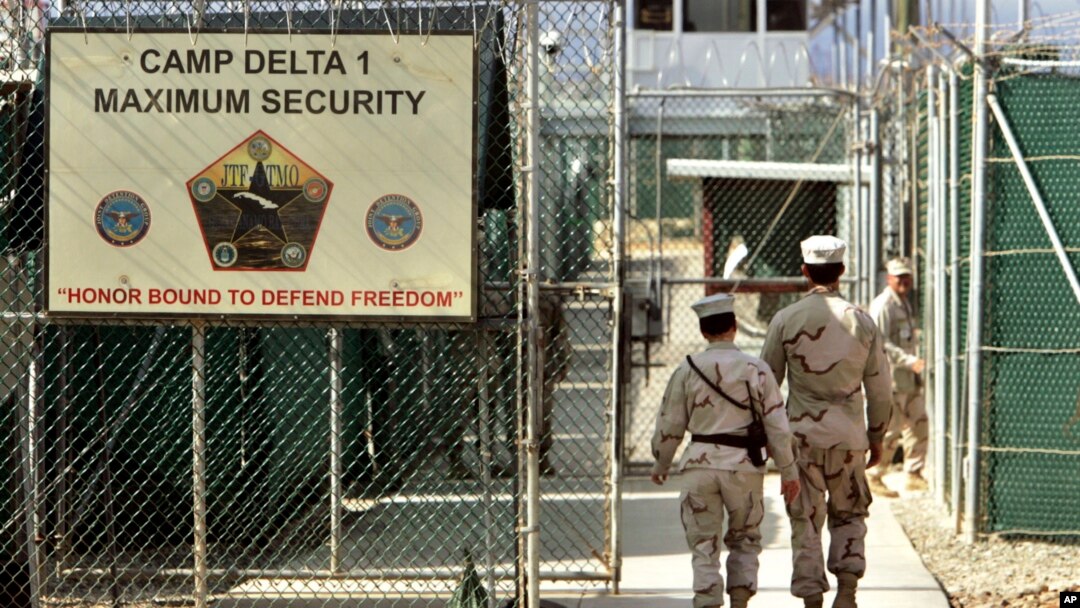 FILE - U.S. military guards enter the Camp Delta military-run prison, at the Guantanamo Bay U.S. Naval Base, Cuba, June 27, 2006. 