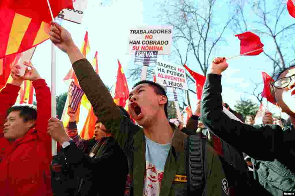 Chinese customers of Spanish bank BBVA protest outside its headquarters in Madrid, Spain. The signs read: &#39;The workers have not been paid their salary&#39; (L) and &#39;Mothers have not been able to feed their children.&#39;