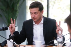 Ukrainian President Volodymyr Zelenskiy speaks during talks with journalists in Kyiv, Ukraine, Oct. 10, 2019. The Ukrainian leader is holding an all-day “media marathon” in a Kyiv food court amid growing questions about his actions as president.