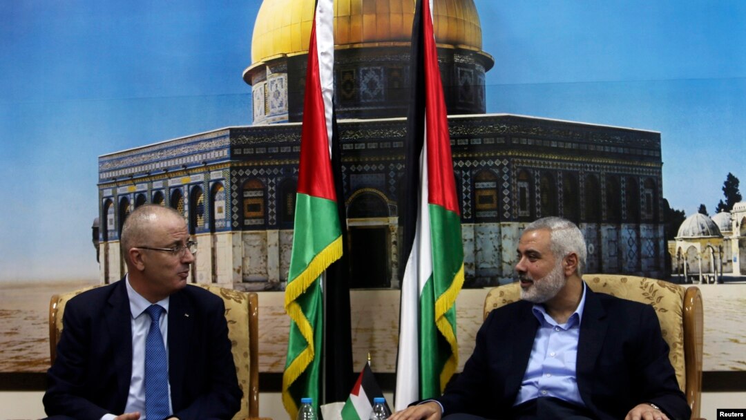 Senior Hamas leader Ismail Haniyeh (R) speaks with Palestinian Prime Minister Rami Hamdallah at Haniyeh's house in Gaza City, Oct. 9, 2014. 