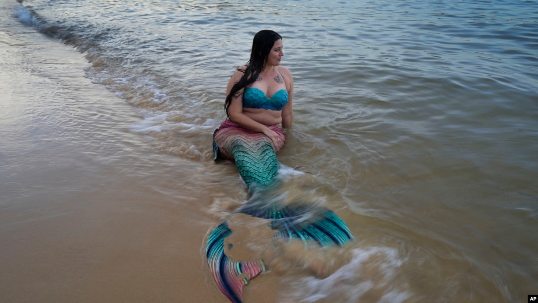FILE - Lauren Metzler prepares for a swim at Manly Cove Beach in Sydney, Australia, Thursday, May 26, 2022. Mermaid does not have to worry about sink or swim. (AP Photo/Mark Baker)