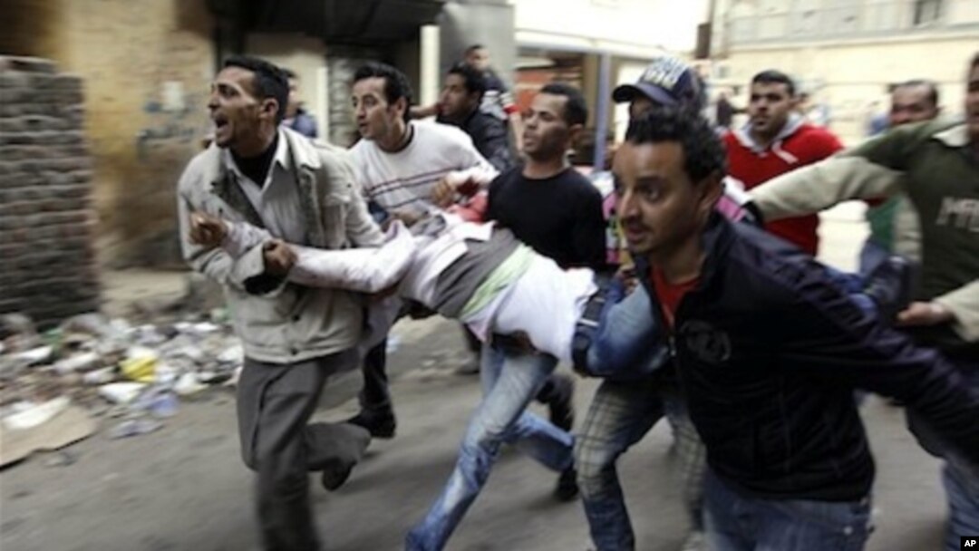 Egyptians carry an injured protester during clashes with anti-riot police in Cairo, Egypt, Saturday, Jan. 29, 2011.
