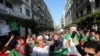 Demonstrators carry national flags as they march, a year since the start of weekly protests calling for a complete overhaul of the ruling elite, an end to corruption and the army's withdrawal from politics, in Algiers, Algeria, Feb. 14, 2020.