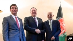 U.S. Secretary of State Mike Pompeo, center, shakes hands with Afghan President Ashraf Ghani, right, as U.S. Secretary of Defense Mark Esper watches during the 56th Munich Security Conference in Munich, Germany, Feb. 14, 2020.