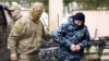 A Ukrainian sailor, right, is escorted by a Russian intelligence officer to a court room in Simferopol, Crimea, Nov. 27, 2018. 