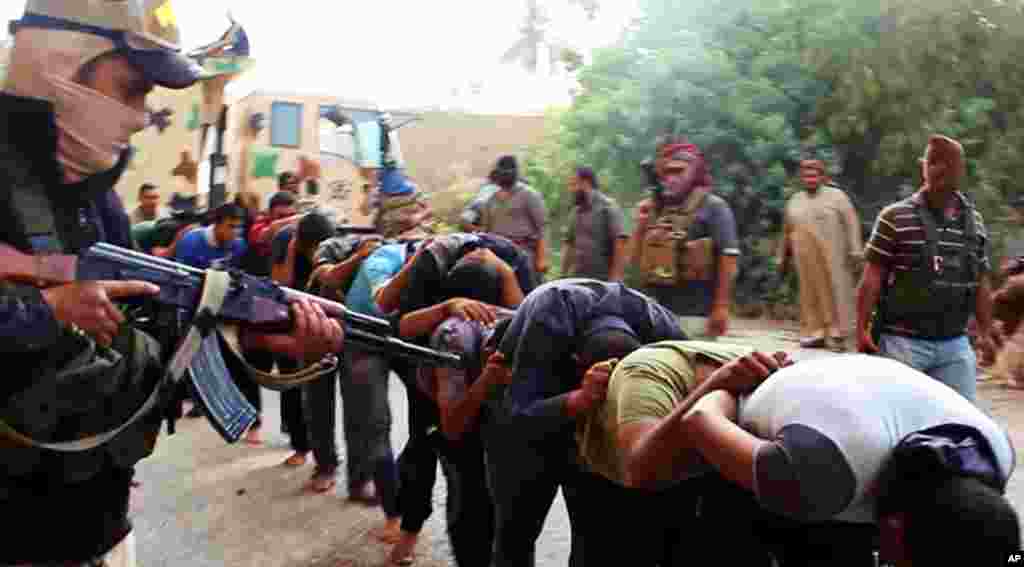 This image posted on a militant website on June 14, 2014 appears to show militants from the Islamic State of Iraq and the Levant with captured Iraqi soldiers wearing plain clothes after taking over a base in Tikrit, Iraq.