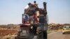 A Syrian family rides with belongings on a tractor-drawn trailer as they flee from fighting in the southern Syrian province of Daraa, June 21, 2018.