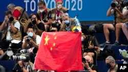 资料照片：在2020东京夏季奥运会一次游泳决赛期间，人们在看台上亮出一面中国旗帜。(2021年7月29日) 