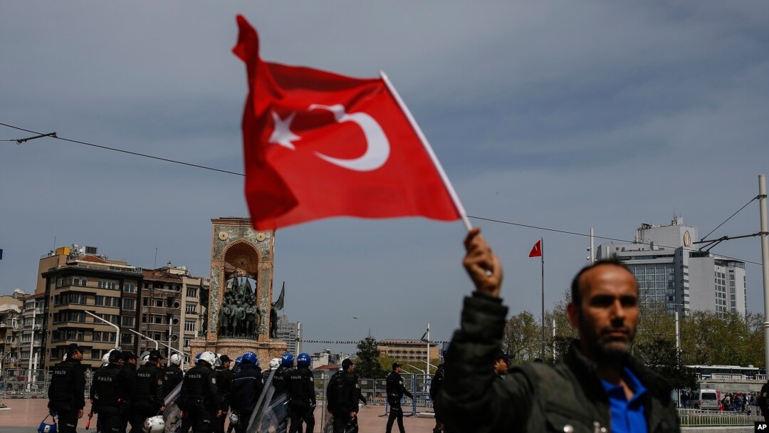 A supporter of Turkey's main opposition Republican People's Party, CHP, waves a national flag as people gather for a sit-in protest in central Istanbul's Taksim Square, Monday, April 16, 2018.