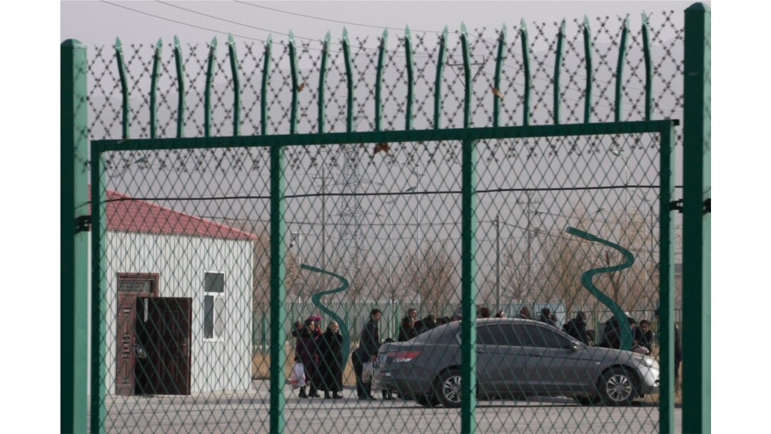 FILE - Residents line up inside the Artux City Vocational Skills Education Training Service Center at the Kunshan Industrial Park in Artux in western China's Xinjiang region, Dec. 3, 2018.