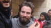 Travis Timmerman, a U.S. citizen who entered Syria from Lebanon on a Christian pilgrimage and was detained for several months, speaks with reporters in a house in Damascus on Dec. 12, 2024, after he was found in the village of Thihabiyeh.