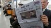 A passenger reads a newspaper with headline of a planned summit meeting between North Korean leader Kim Jong Un and U.S. President Donald Trump, left, at subway train in Seoul, South Korea, March 10, 2018. 